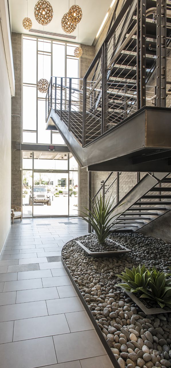 Two-story industrial lobby with steel staircase and pendant lighting